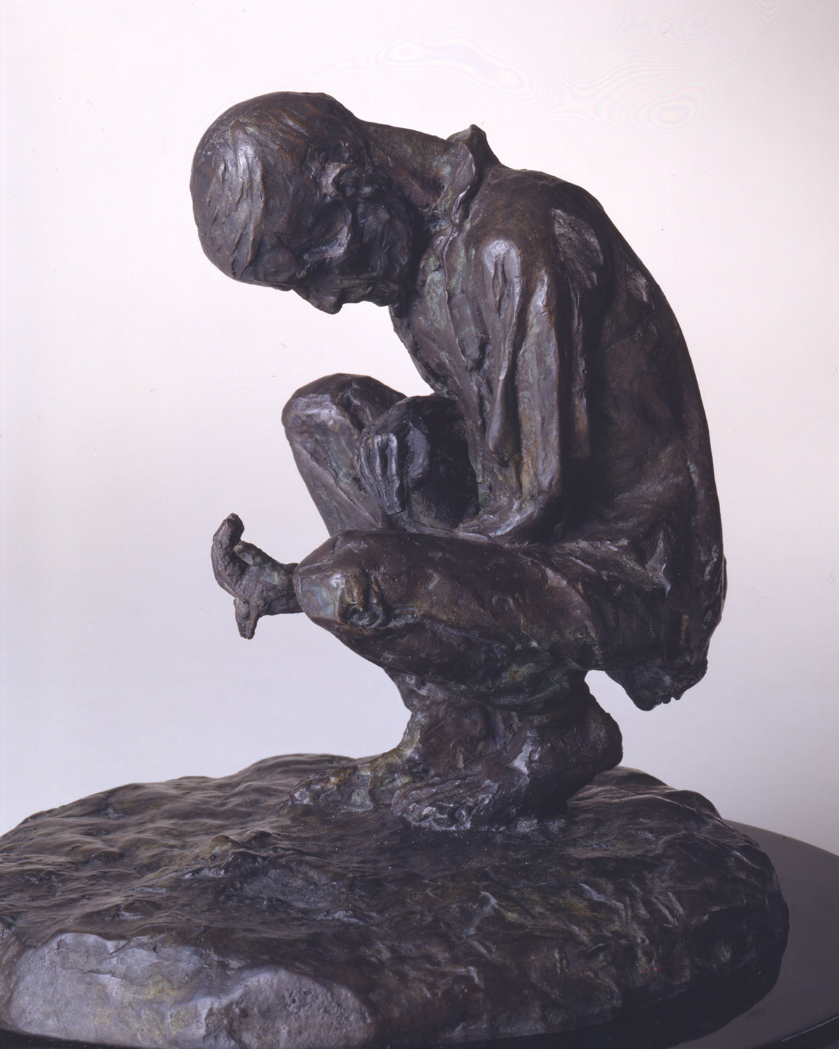 A photo of a sculpture entitled "Man Sifting Through Soil" by the artist Margaret Lyster Chamberlain
